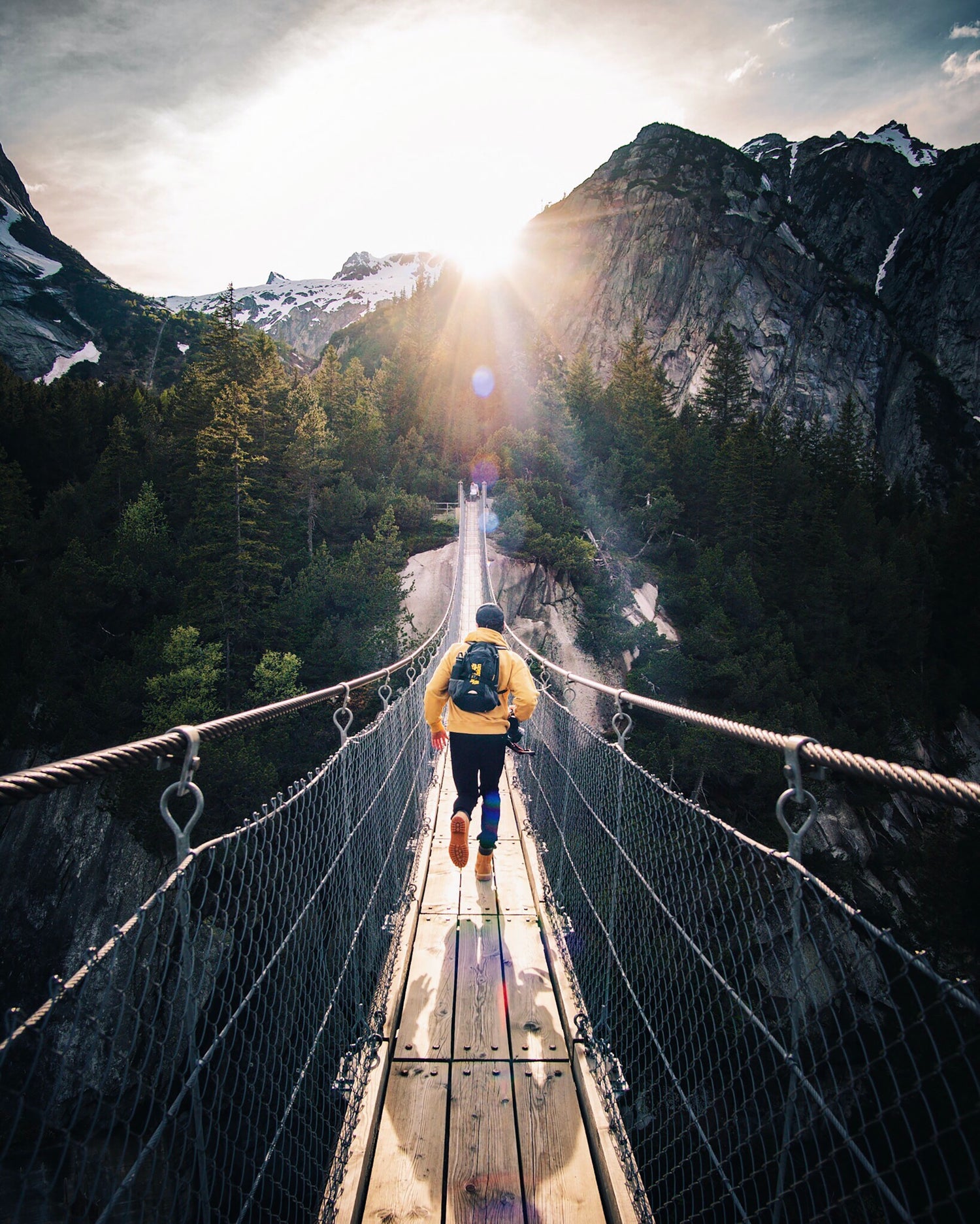 man running over bridge with scenic mountains